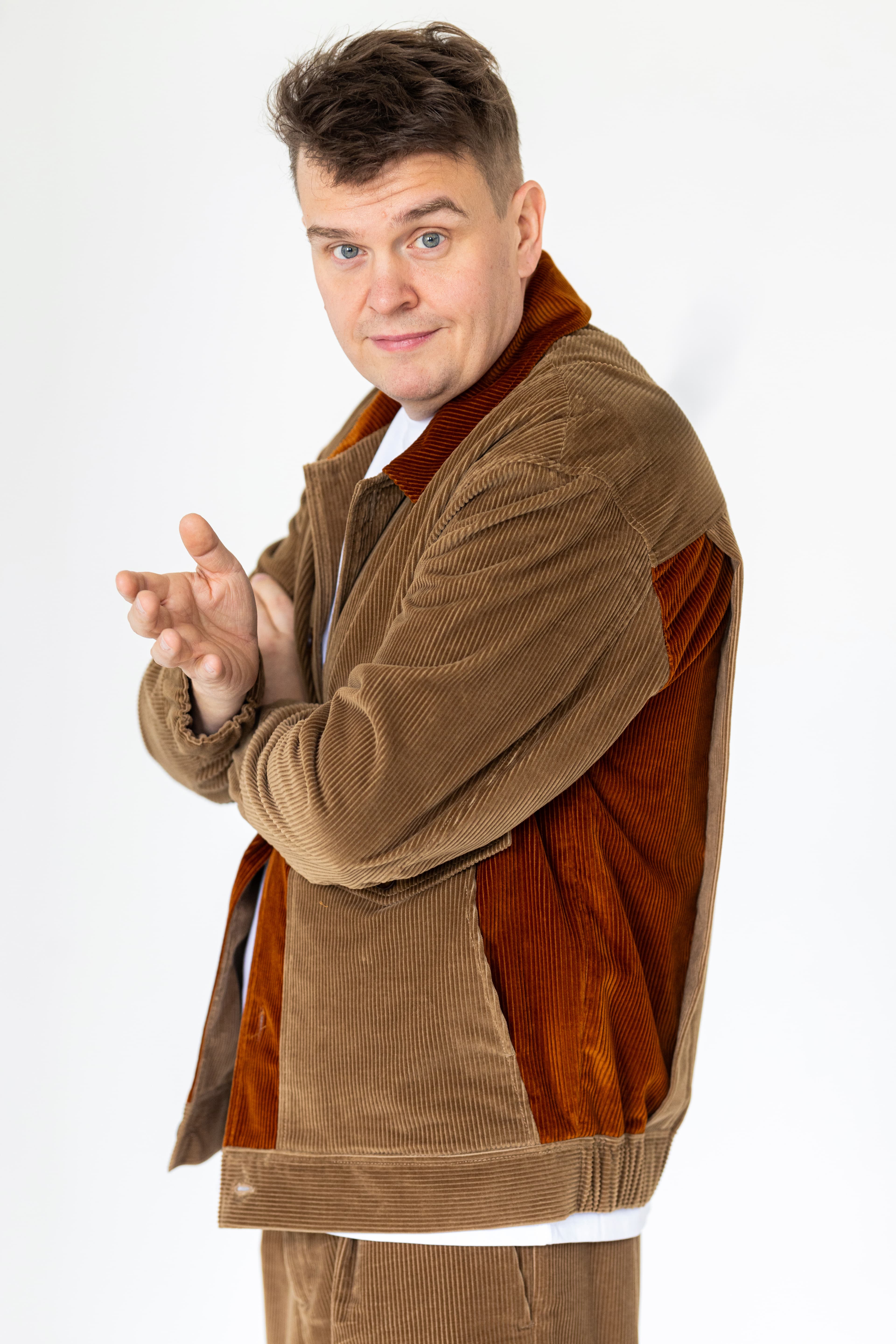 JP Pirinen, smiling and gesturing, in a brown jacket